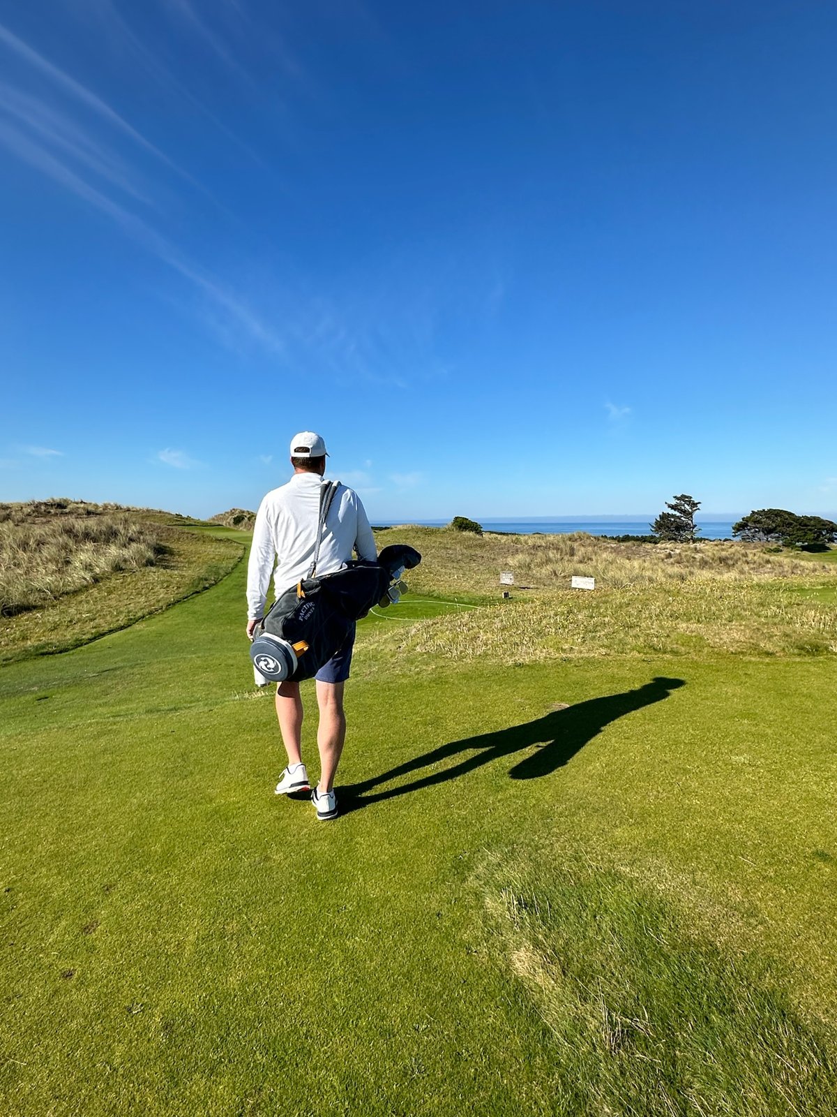David walking a links course carrying his bag